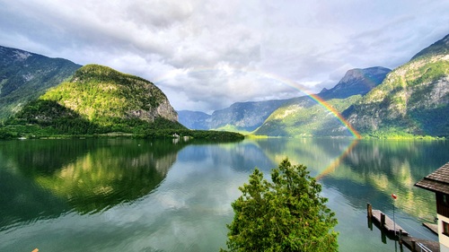 Blick auf den Hallstättersee mit einem wunderschönen Regenbogen vom Himmel über den See, umrahmt von den Bergen